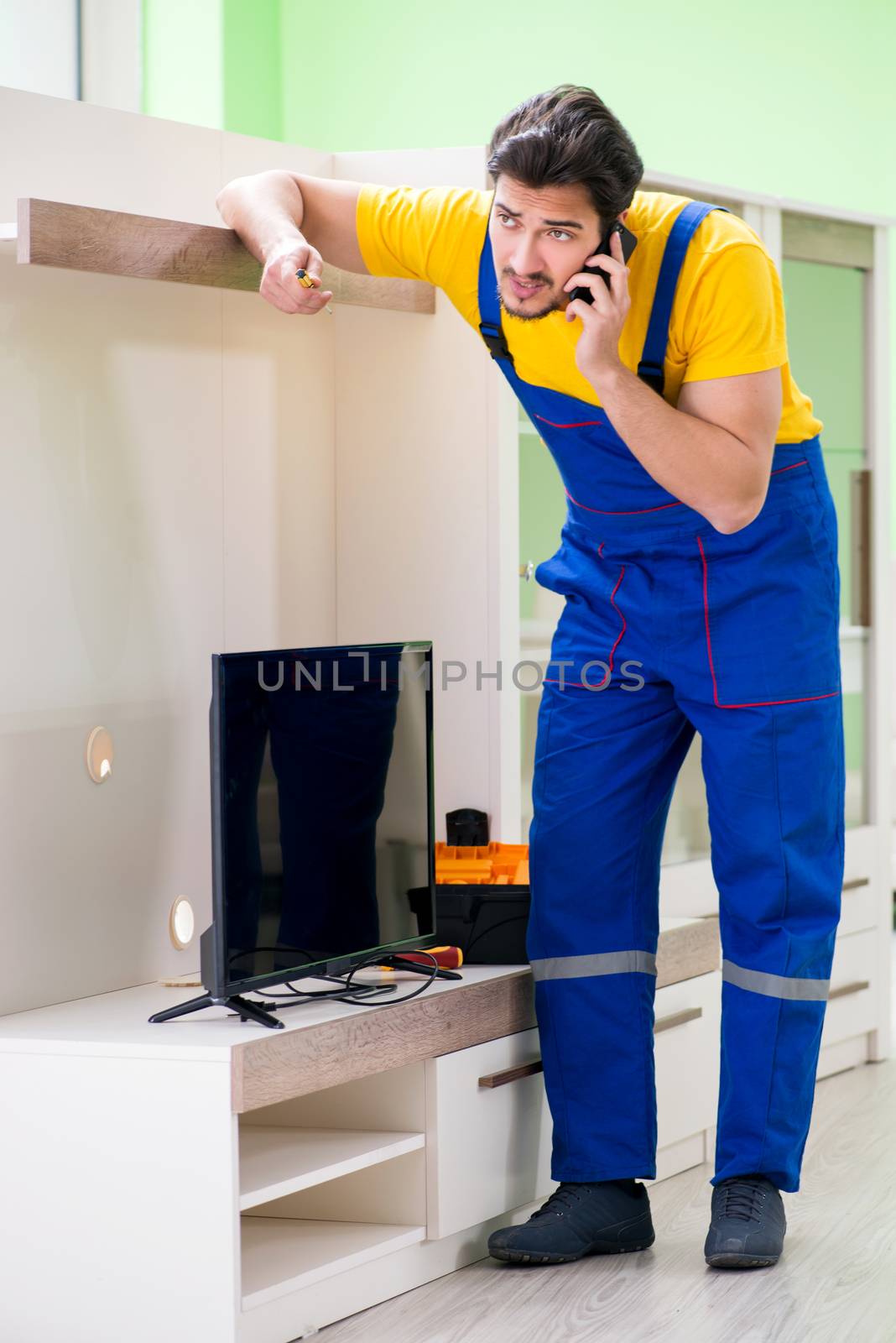 Male professional serviceman repairing tv at home
