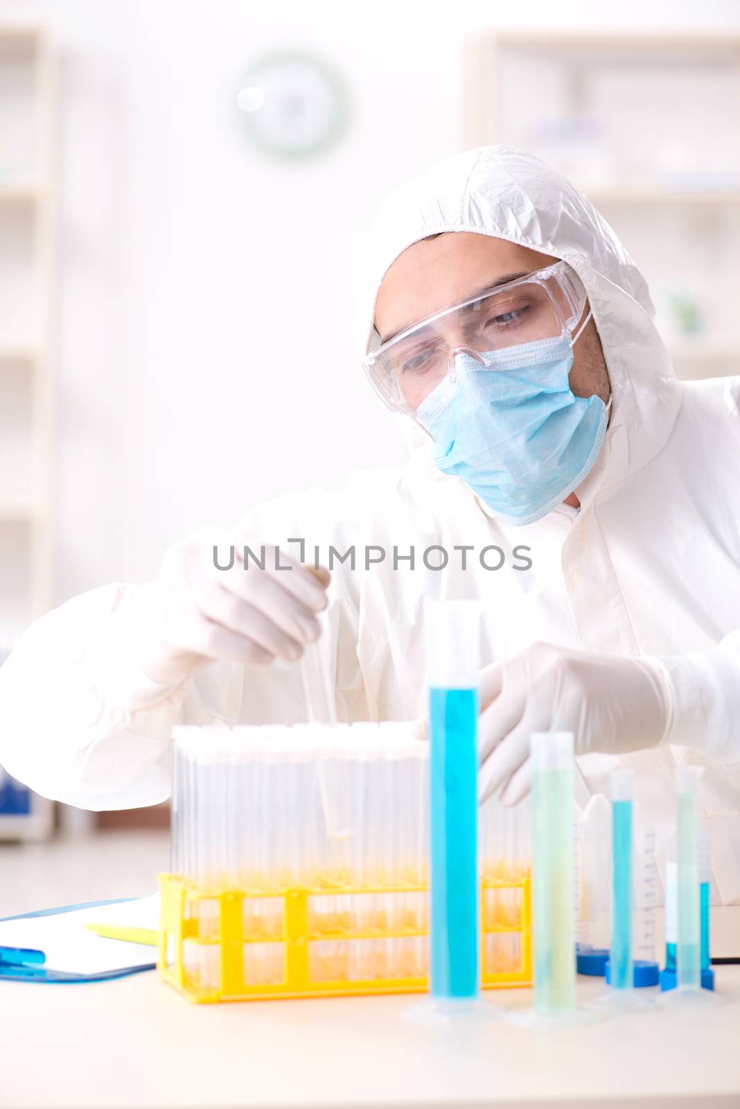 Young chemist student working in lab on chemicals