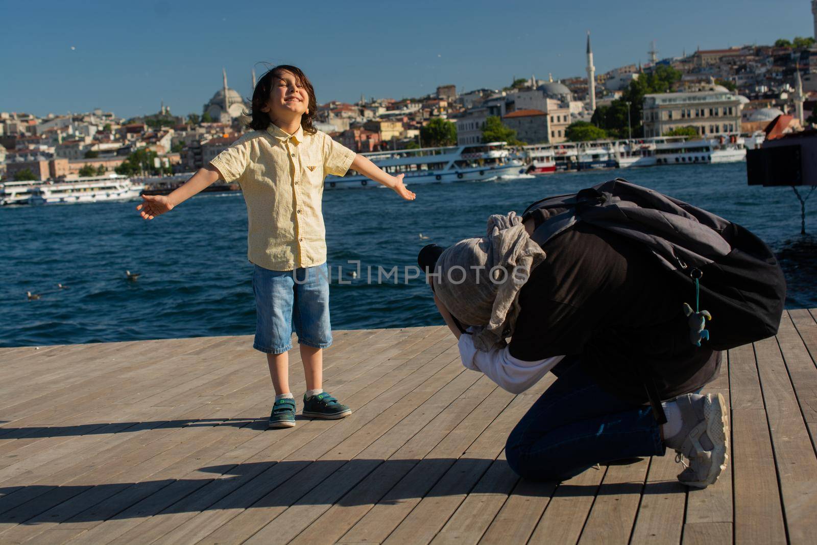 Young girl taking  photo of  boy with Istanbul panorama behind