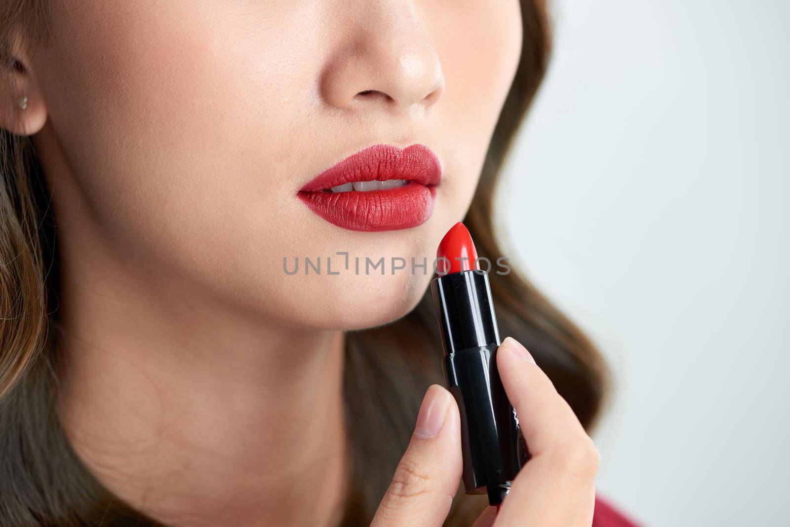 close up of beauty skincare woman take lipstick on the white background by makidotvn