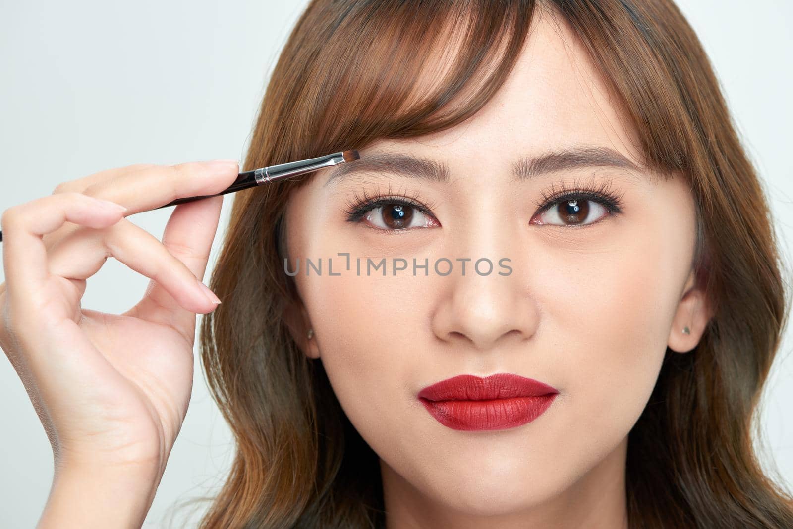 Asian young beautiful woman applying cosmetic powder brush on eyebrow, natural makeup, beauty face by makidotvn