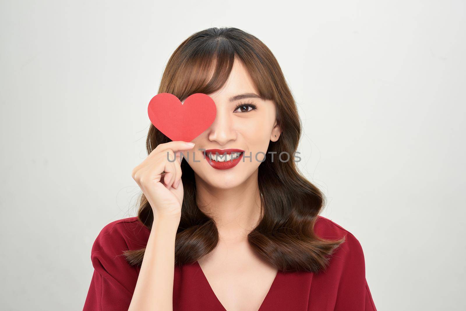 Valentine day concept. Beautiful asian girl holding red heart cover her eyes by makidotvn