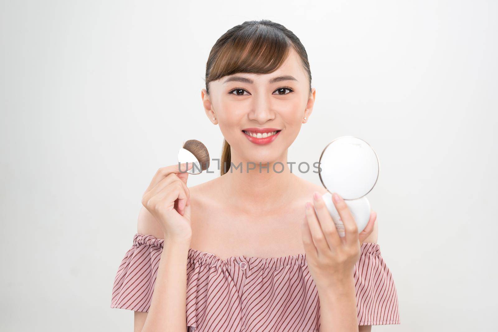 Beautiful Female With Cushion Puff And Mirror Applying Makeup Powder Foundation by makidotvn