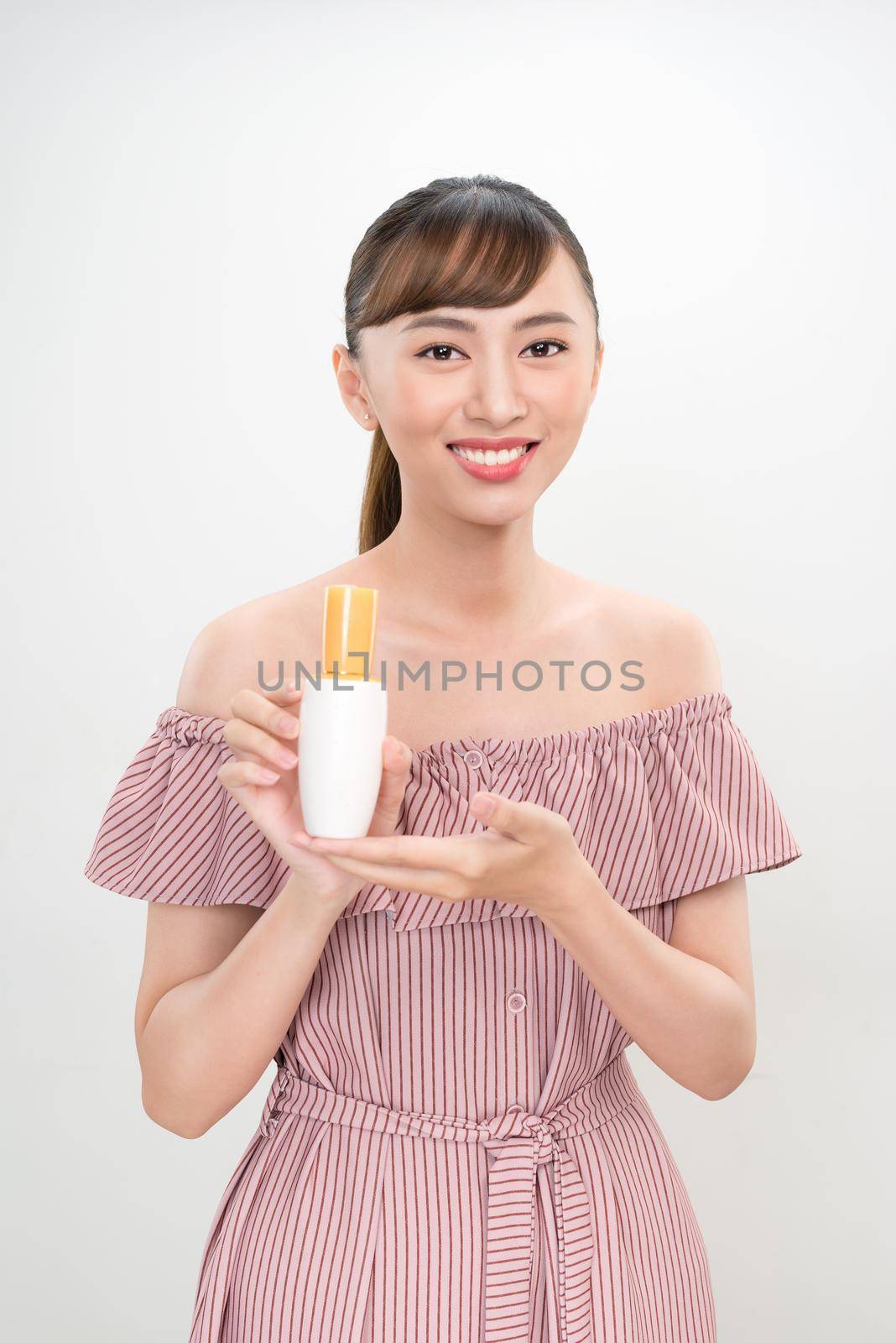 asian woman showing cream on her hand, isolated on white