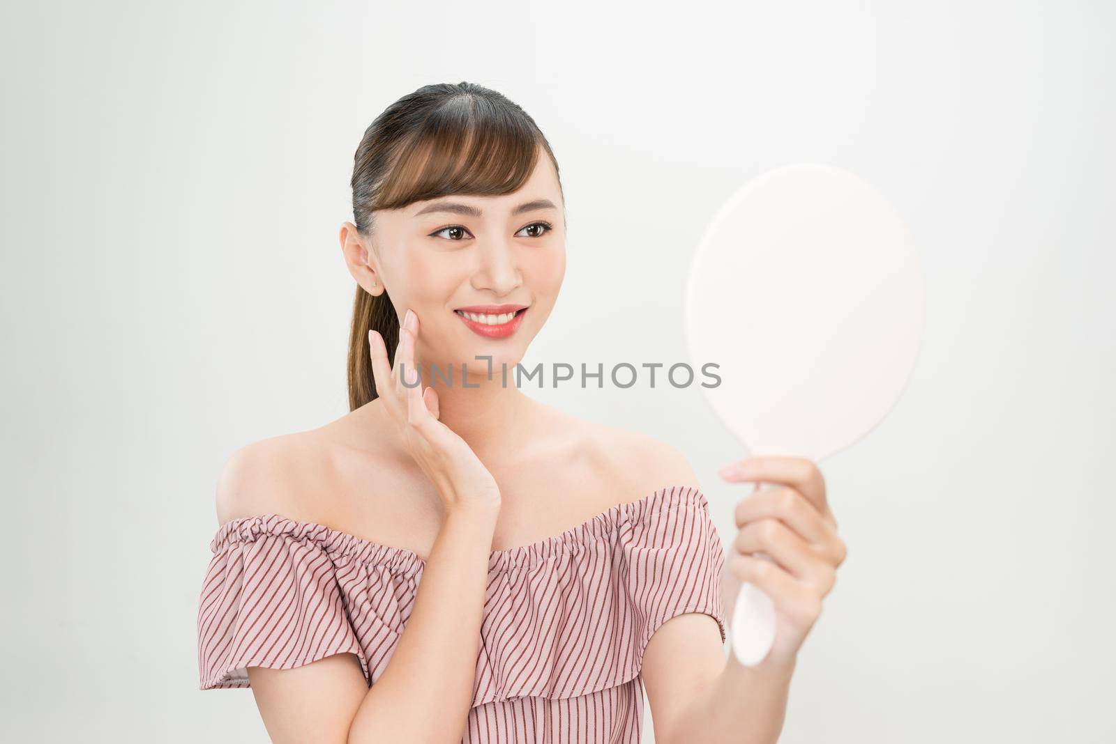 Beautiful smiling girl with natural makeup touching face. by makidotvn