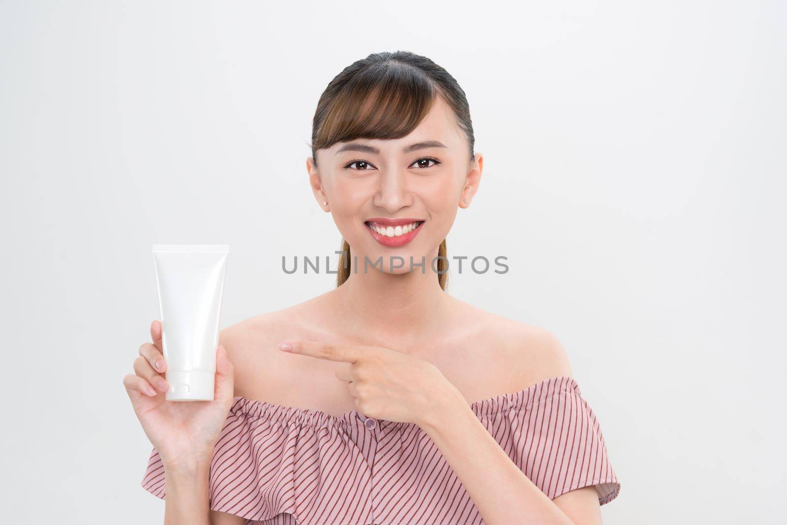 smiling young woman showing skincare products  by makidotvn