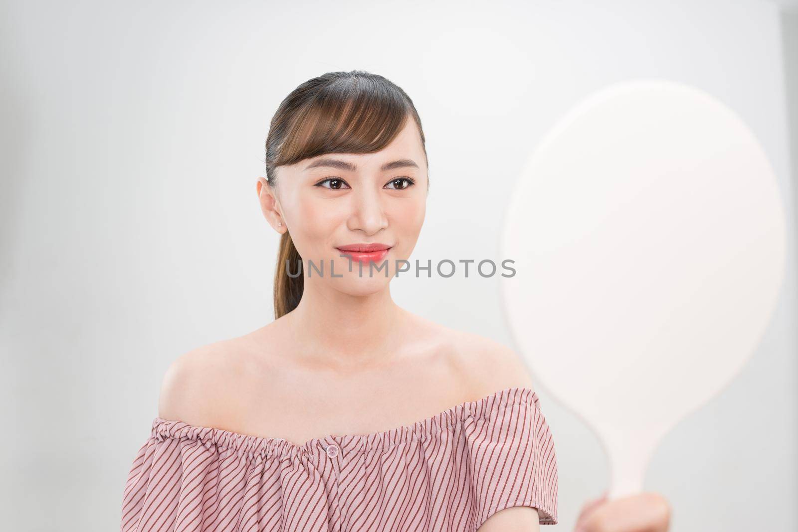 Beautiful smiling girl with natural makeup touching face. by makidotvn