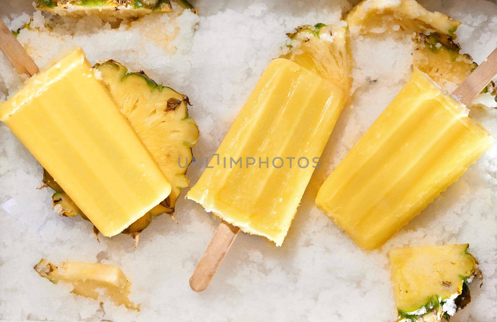 Homemade popsicles with pineapple on stick, top view