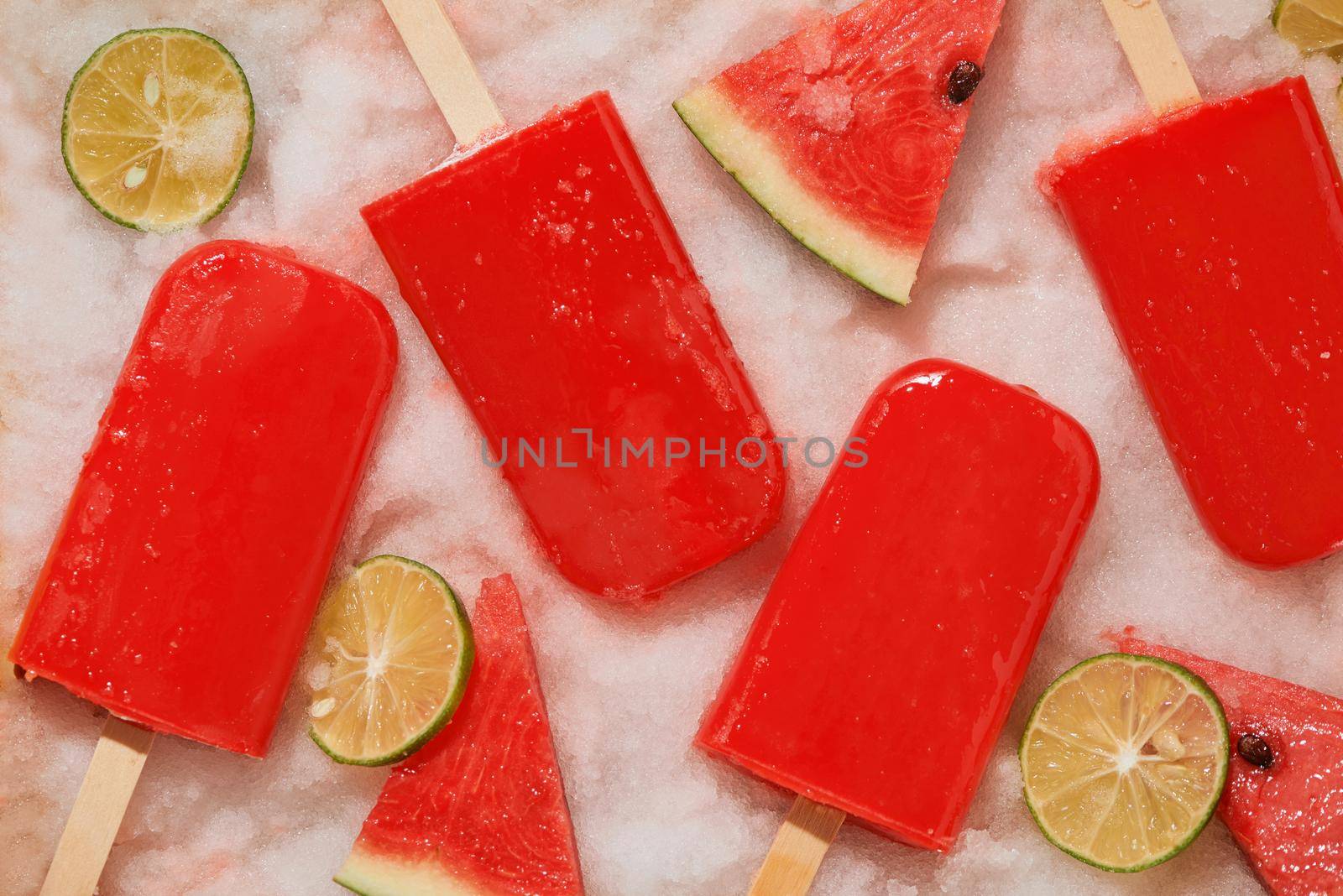 Watermelon popsicle and sliced lemon on ice tray