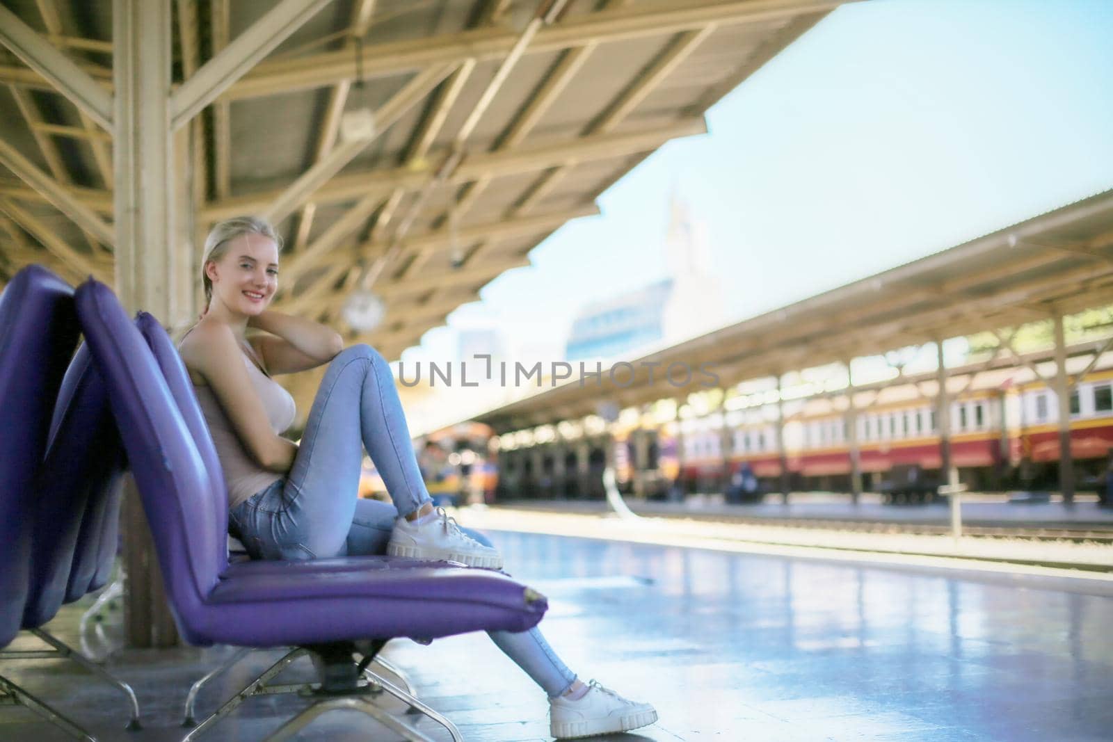 young woman waiting in vintage train, relaxed and carefree at the station platform in Bangkok, Thailand before catching a train. Travel photography. Lifestyle. by chuanchai