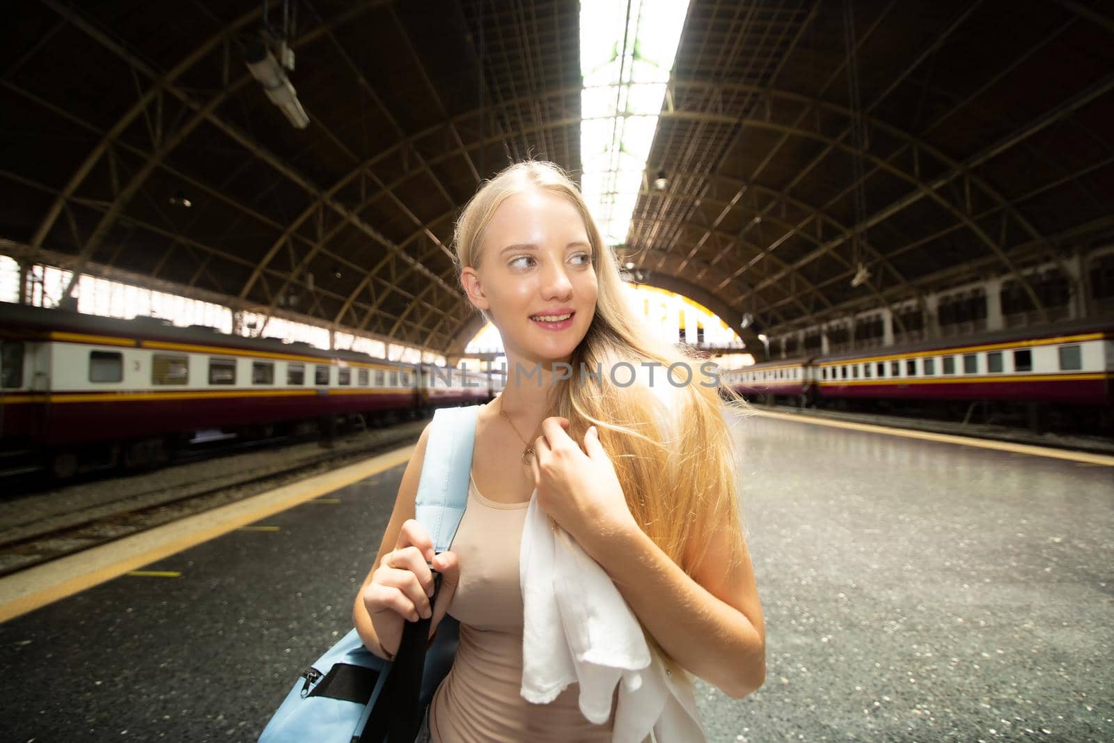 young woman waiting in vintage train, relaxed and carefree at the station platform in Bangkok, Thailand before catching a train. Travel photography. Lifestyle.