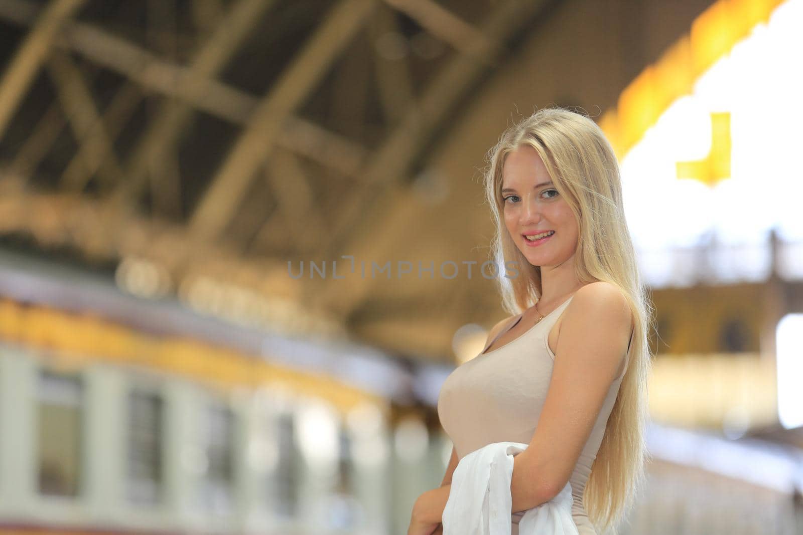 young woman waiting in vintage train, relaxed and carefree at the station platform in Bangkok, Thailand before catching a train. Travel photography. Lifestyle.