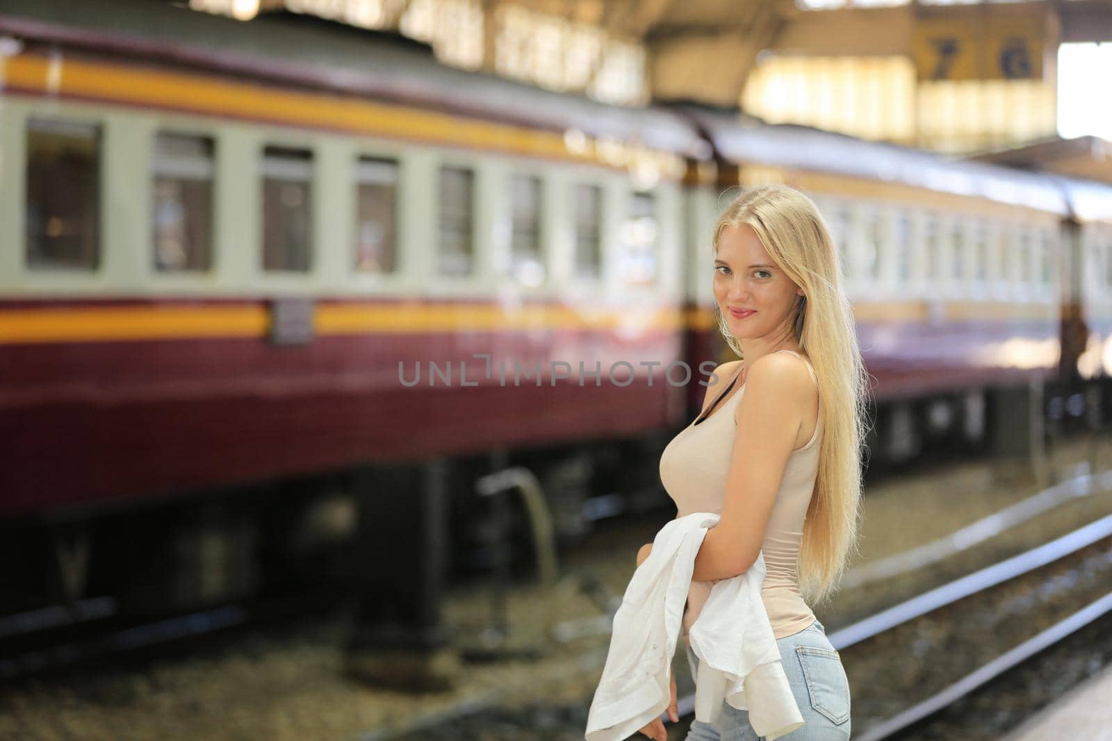 young woman waiting in vintage train, relaxed and carefree at the station platform in Bangkok, Thailand before catching a train. Travel photography. Lifestyle. by chuanchai