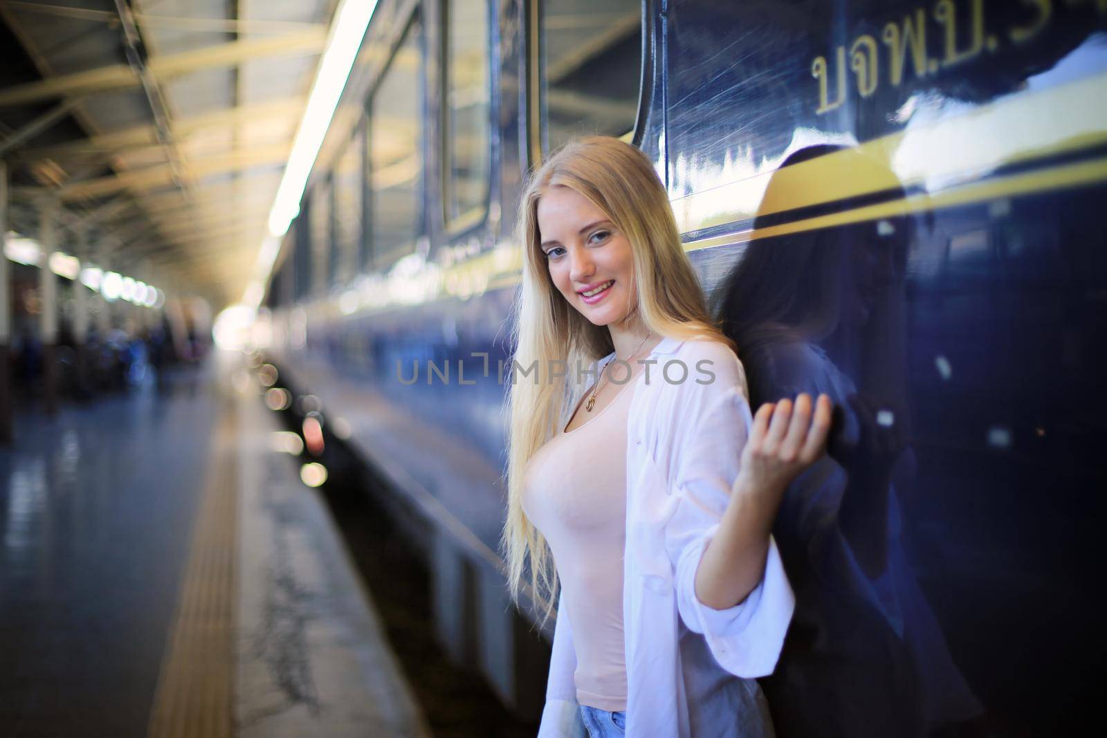 young woman waiting in vintage train, relaxed and carefree at the station platform in Bangkok, Thailand before catching a train. Travel photography. Lifestyle. by chuanchai