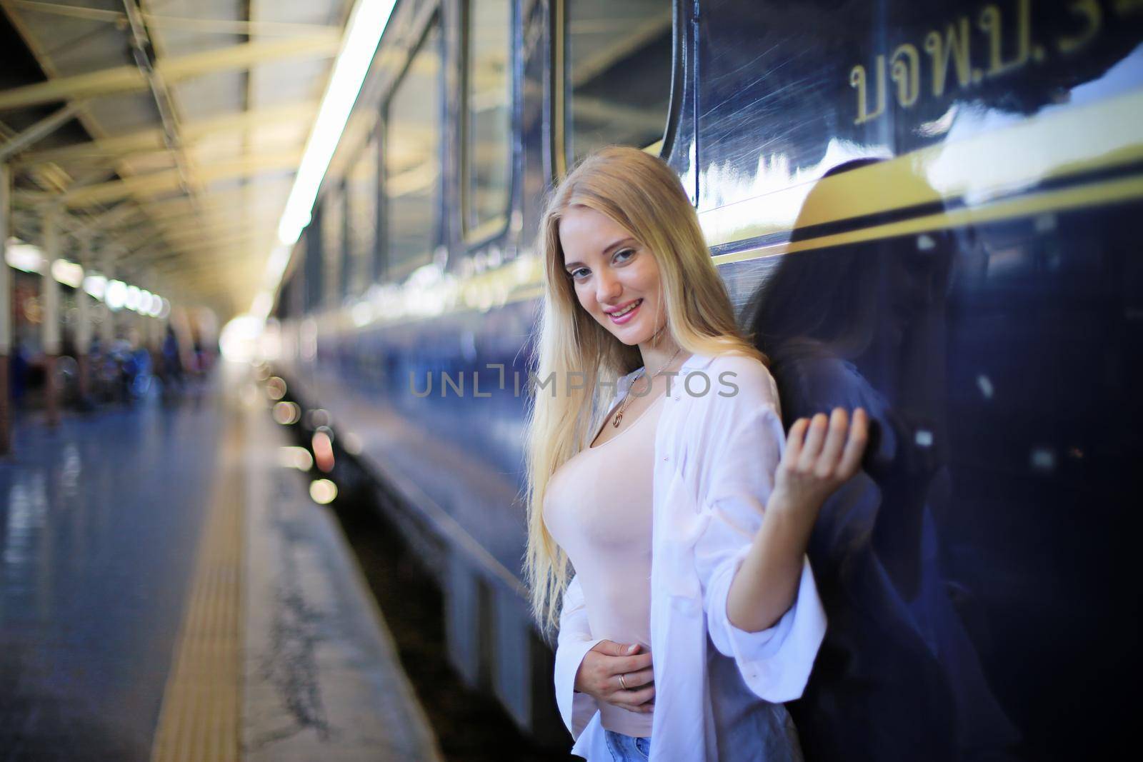 young woman waiting in vintage train, relaxed and carefree at the station platform in Bangkok, Thailand before catching a train. Travel photography. Lifestyle. by chuanchai