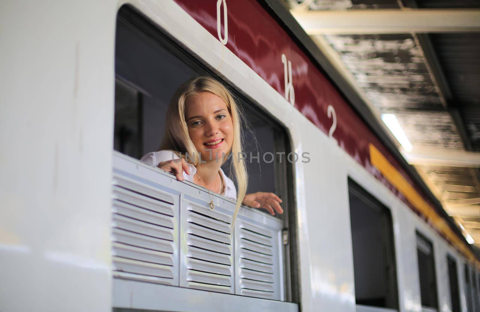 young woman waiting in vintage train, relaxed and carefree at the station platform in Bangkok, Thailand before catching a train. Travel photography. Lifestyle. by chuanchai