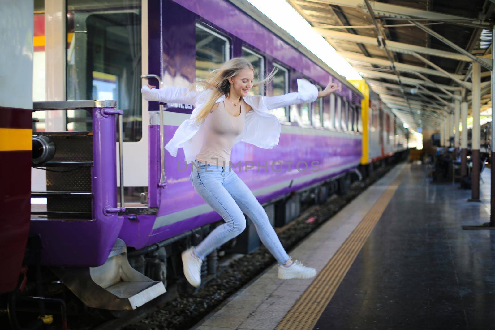 young woman waiting in vintage train, relaxed and carefree at the station platform in Bangkok, Thailand before catching a train. Travel photography. Lifestyle. by chuanchai