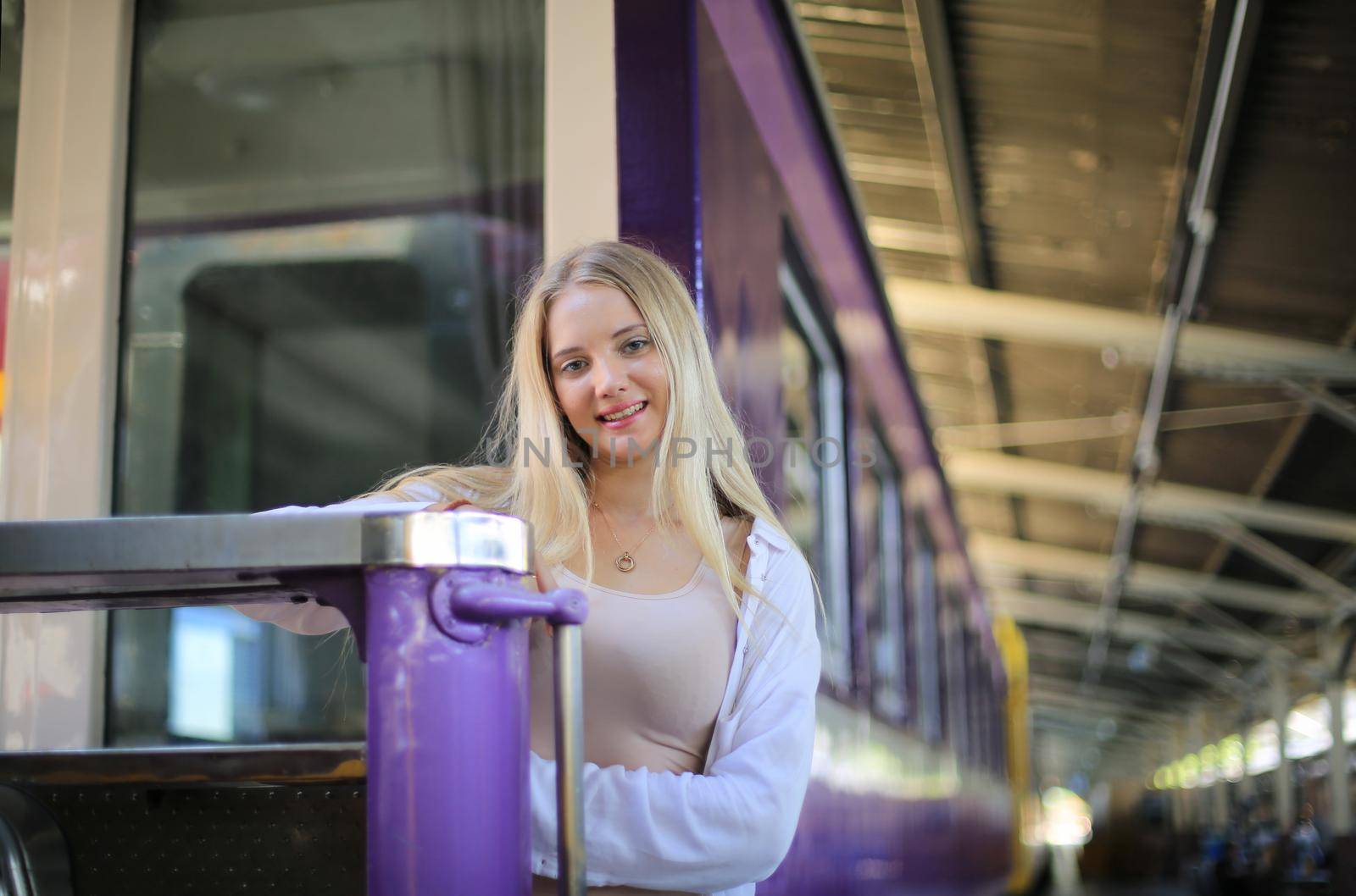 young woman waiting in vintage train, relaxed and carefree at the station platform in Bangkok, Thailand before catching a train. Travel photography. Lifestyle. by chuanchai