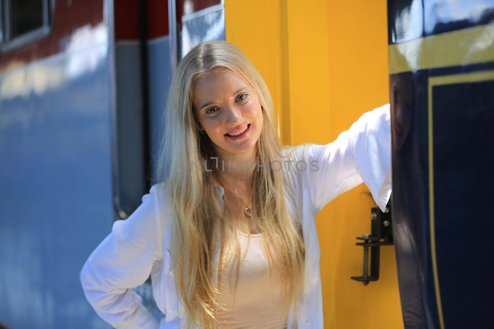 young woman waiting in vintage train, relaxed and carefree at the station platform in Bangkok, Thailand before catching a train. Travel photography. Lifestyle.