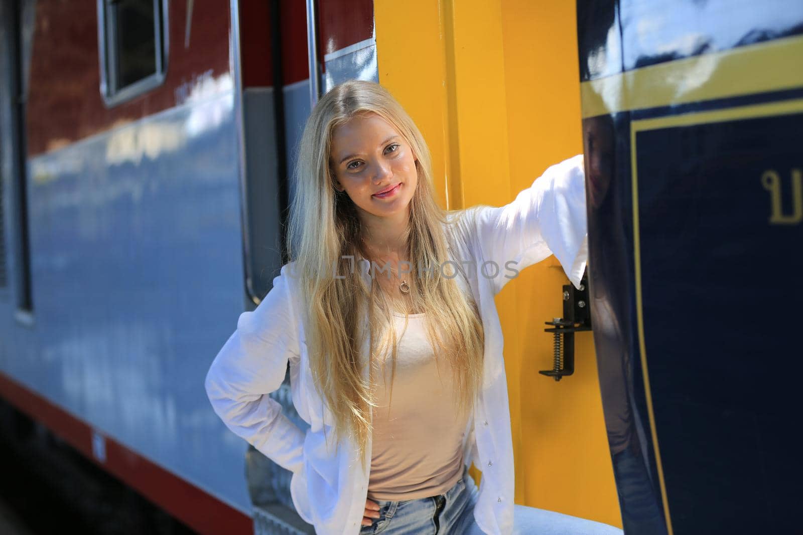 young woman waiting in vintage train, relaxed and carefree at the station platform in Bangkok, Thailand before catching a train. Travel photography. Lifestyle. by chuanchai