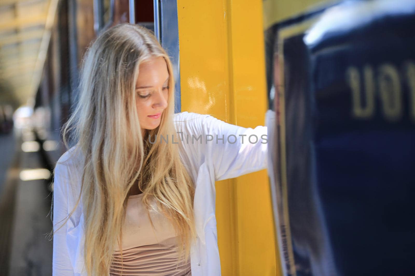 young woman waiting in vintage train, relaxed and carefree at the station platform in Bangkok, Thailand before catching a train. Travel photography. Lifestyle. by chuanchai