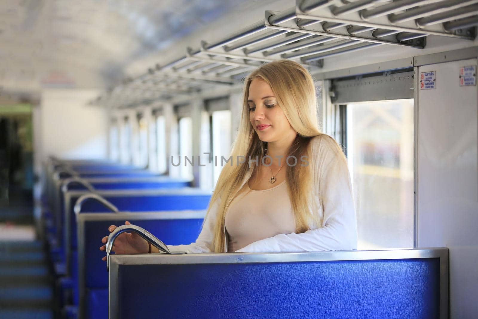 young woman waiting in vintage train, relaxed and carefree at the station platform in Bangkok, Thailand before catching a train. Travel photography. Lifestyle. by chuanchai