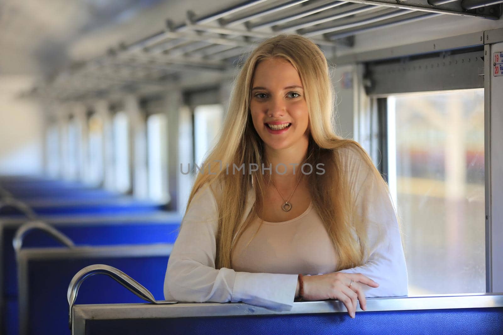 young woman waiting in vintage train, relaxed and carefree at the station platform in Bangkok, Thailand before catching a train. Travel photography. Lifestyle.