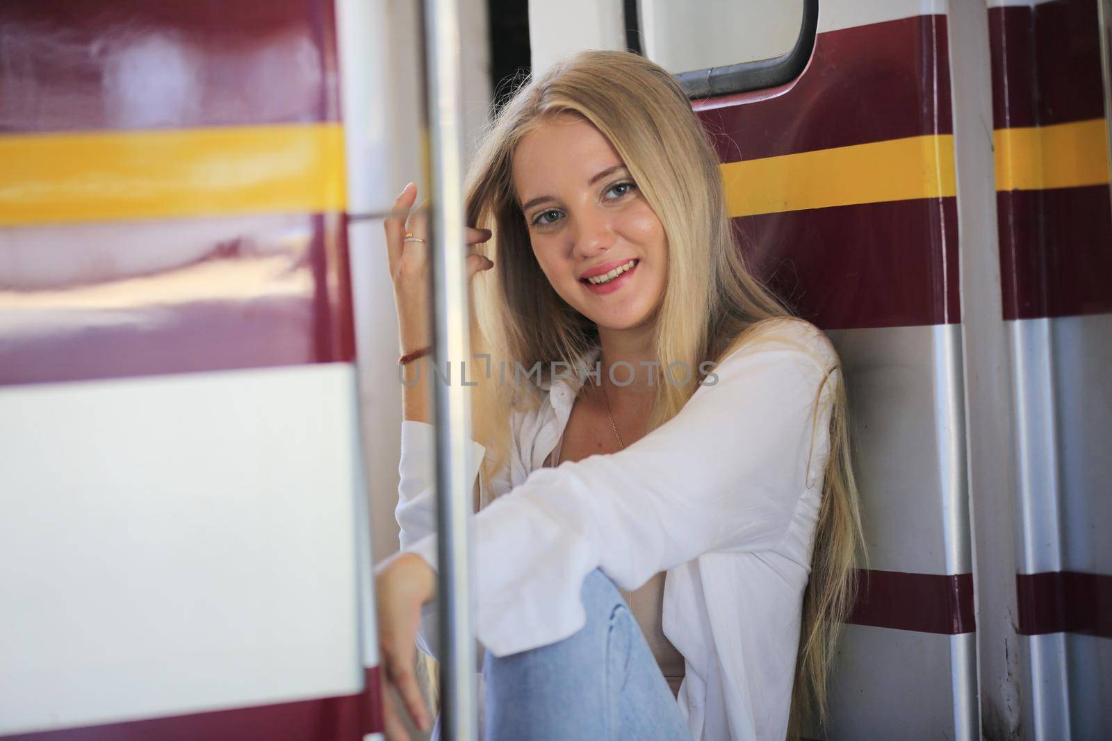 young woman waiting in vintage train, relaxed and carefree at the station platform in Bangkok, Thailand before catching a train. Travel photography. Lifestyle. by chuanchai