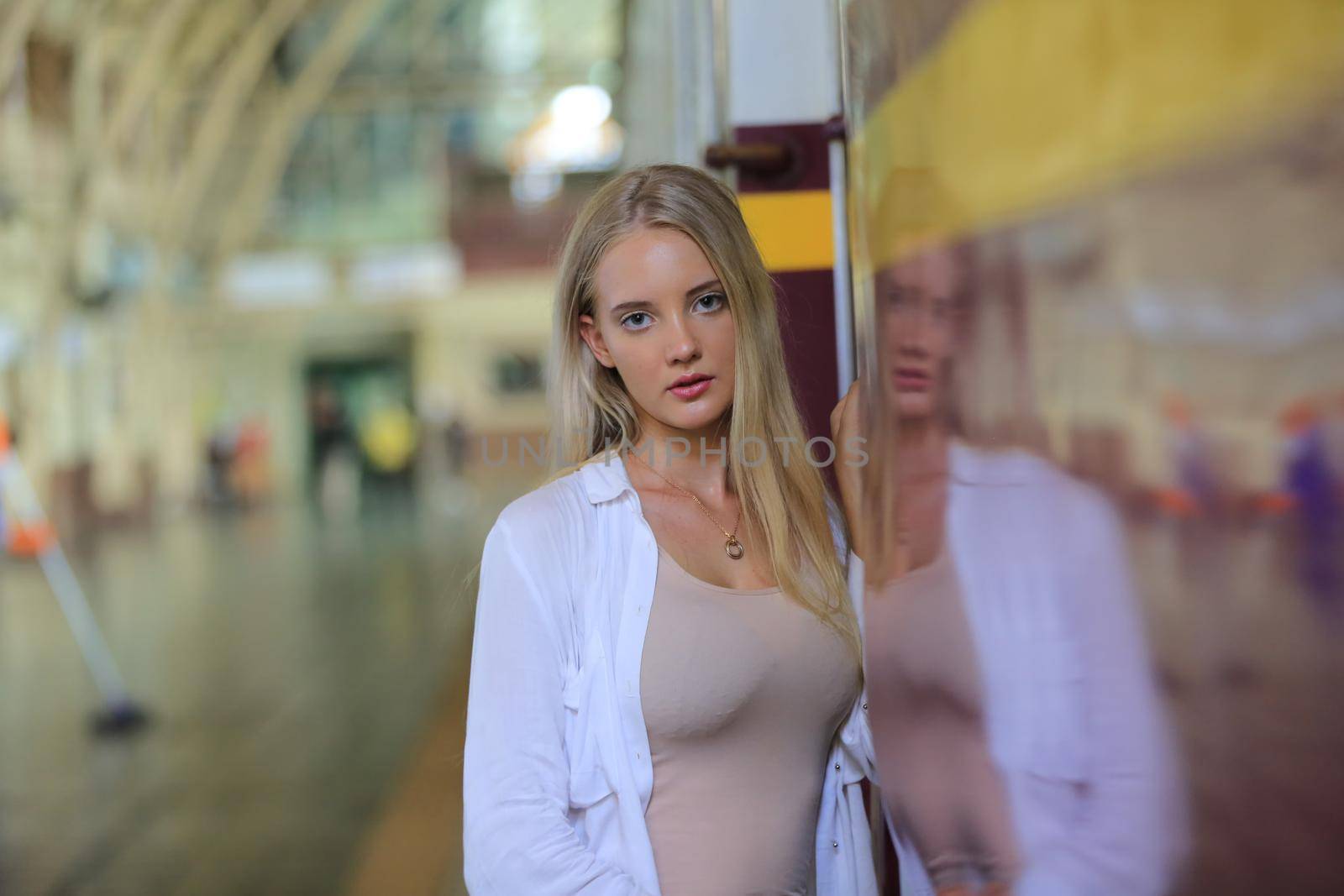 young woman waiting in vintage train, relaxed and carefree at the station platform in Bangkok, Thailand before catching a train. Travel photography. Lifestyle.