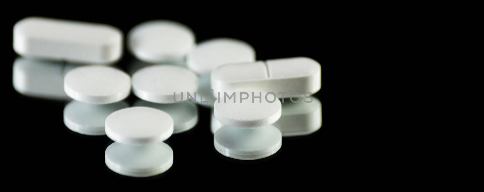 scattered tablets on a black background, pills reflected in the mirror by Q77photo