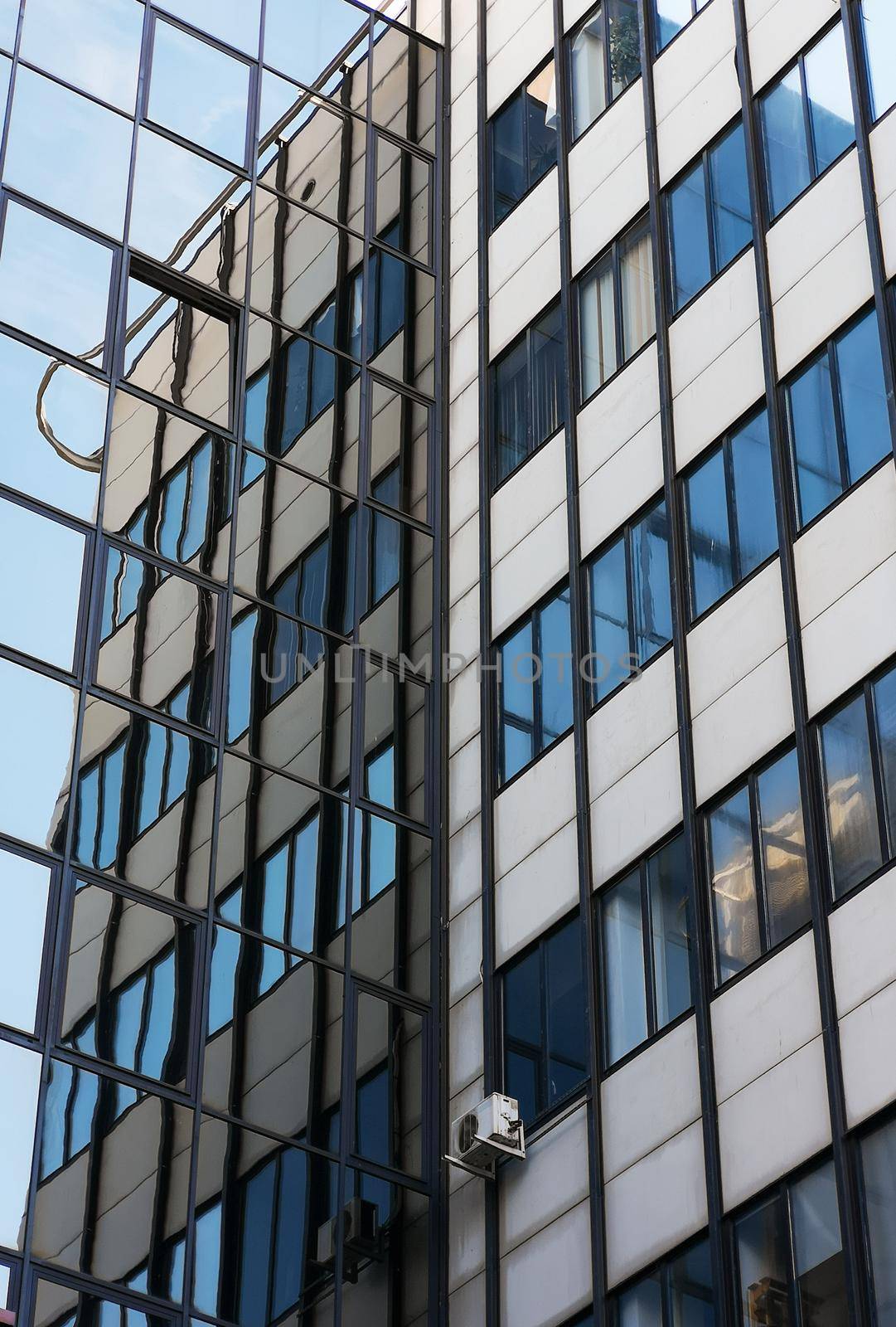 Looking up to facade of building reflecting in windows