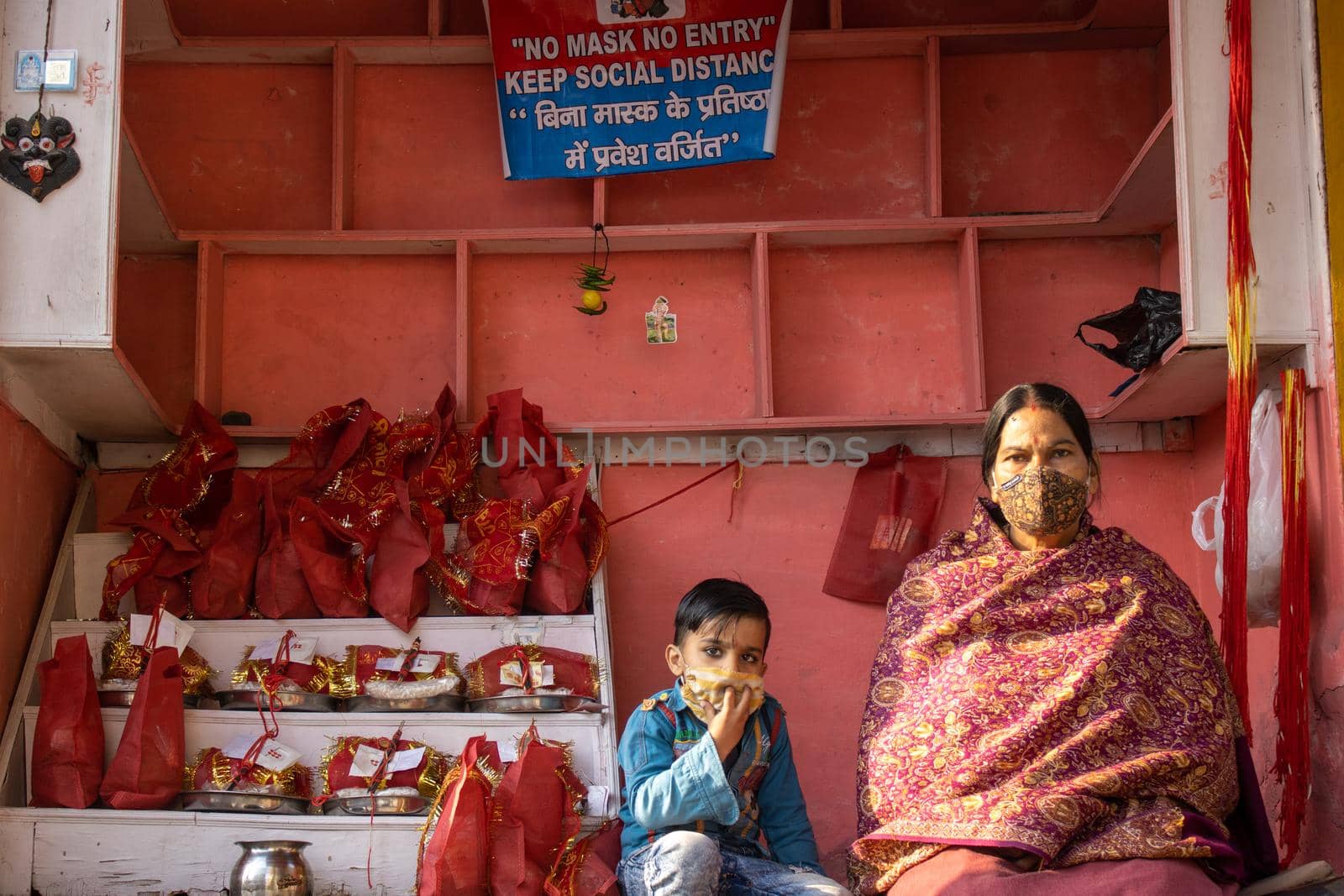 Haridwar, Uttarakhand, India, April 14, 2021.Indian woman shopkeeper with her child at shop selling religious material at Haridwar Uttarakhand India . High quality photo