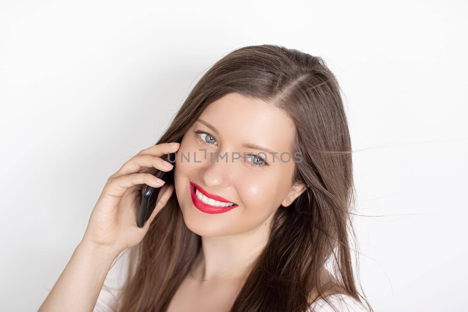 Happy smiling woman calling on smartphone, portrait on white background. People, technology and communication concept by Anneleven