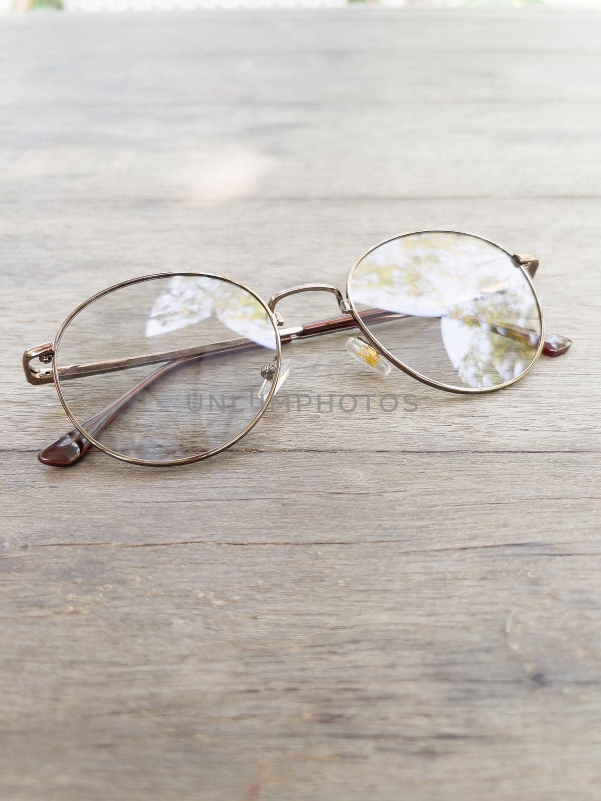 Eyeglasses on old wooden table by punsayaporn