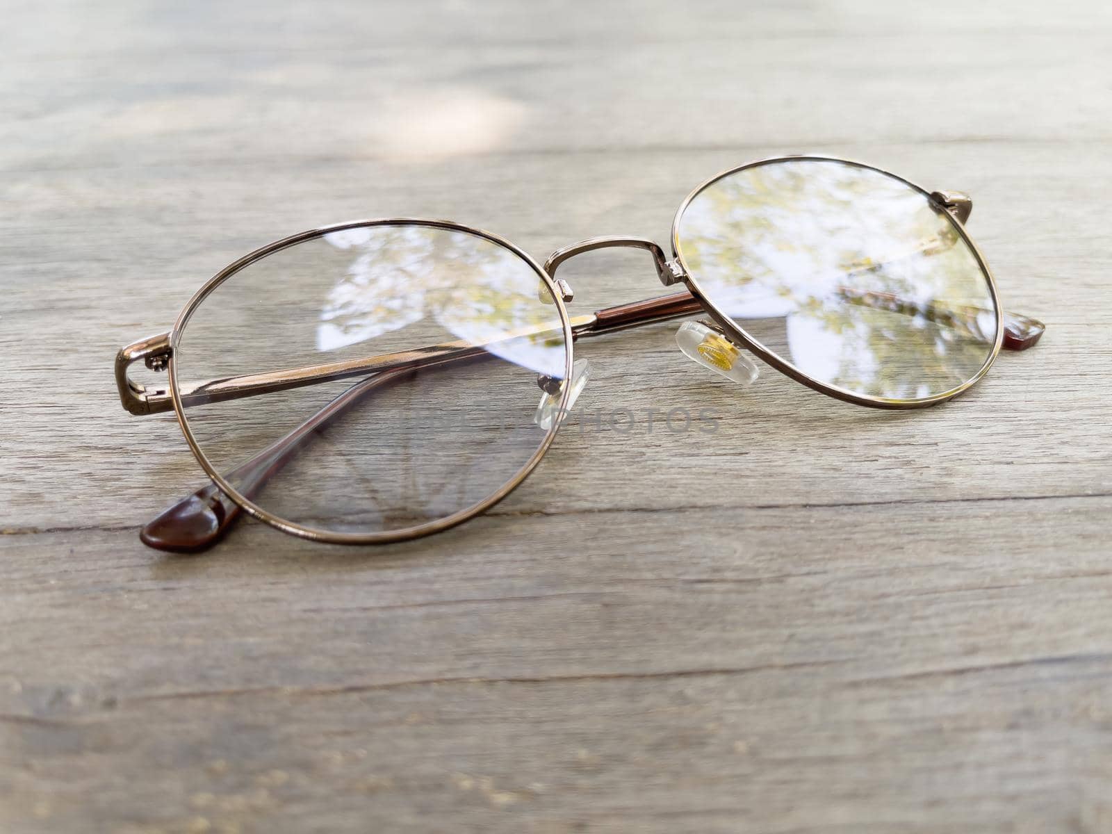 Eyeglasses on old wooden table by punsayaporn