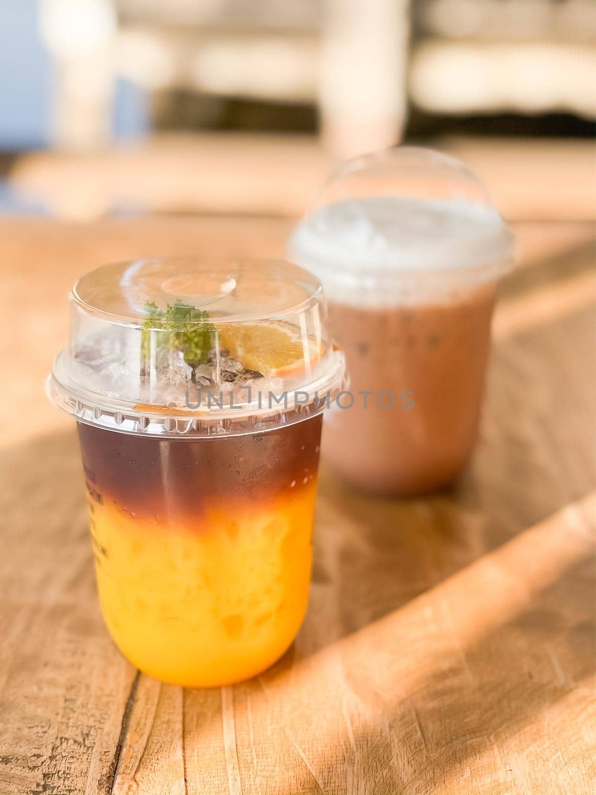 A glass of iced americano with orange juice by punsayaporn