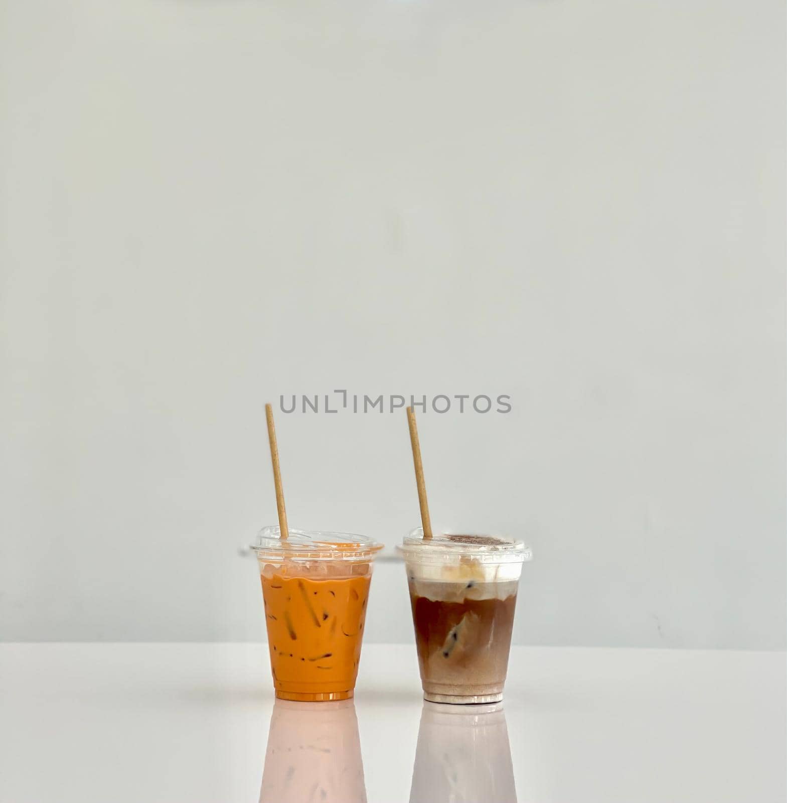 A glass of iced mocha and iced thai milk tea by punsayaporn