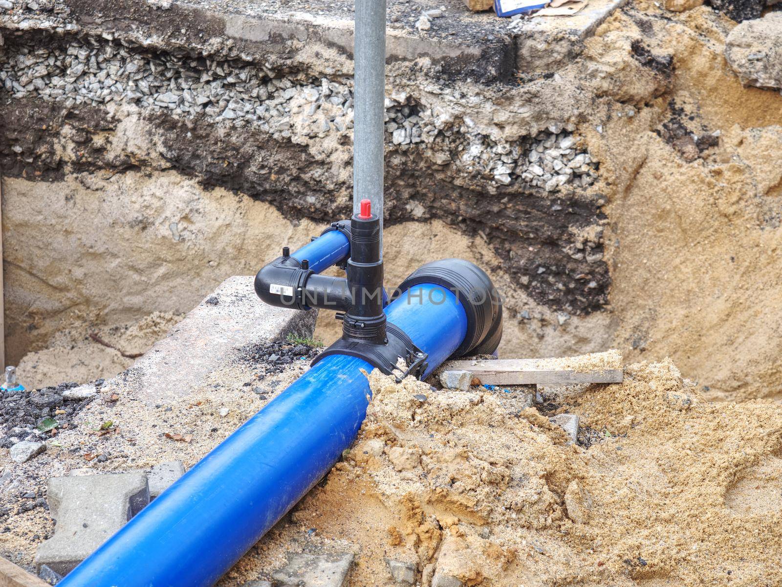 Valve and HDPE pipe welded underground. City potable water system. MAn water supply plastic tubes, excavation pit