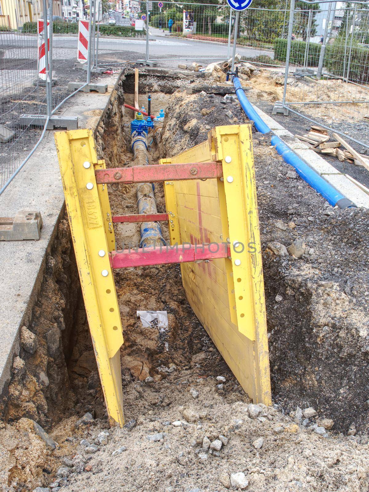 Flat steel formwork concrete strip foundation for water inspection shaft under street pavement. Complete rebuilding water system from steel to plastic tube