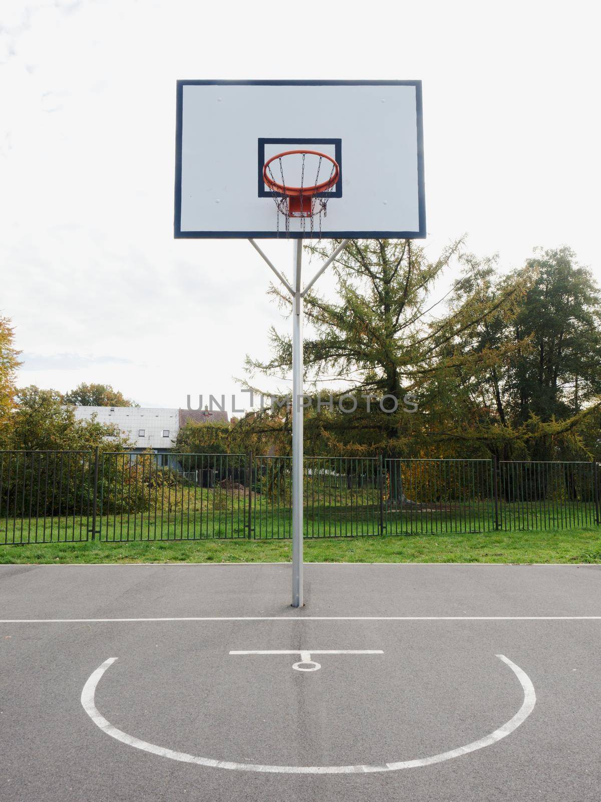 Basketball hoop and a cage with poor asphalt, sports background