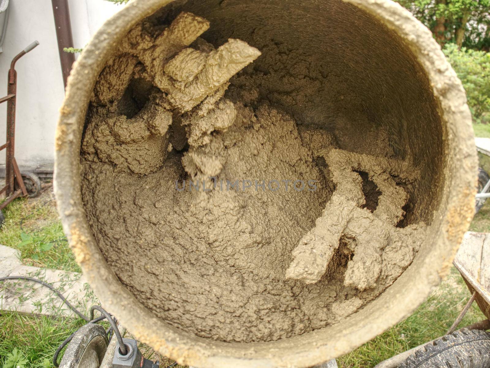 Mix of wet cement concrete in mobile mixer. Concrete mixing for building in detail. 