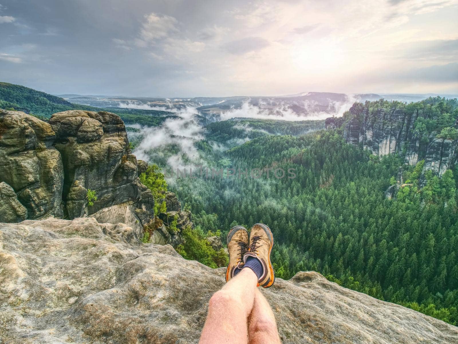 Naked legs of successful hiker on exposed sandstone rock  by rdonar2