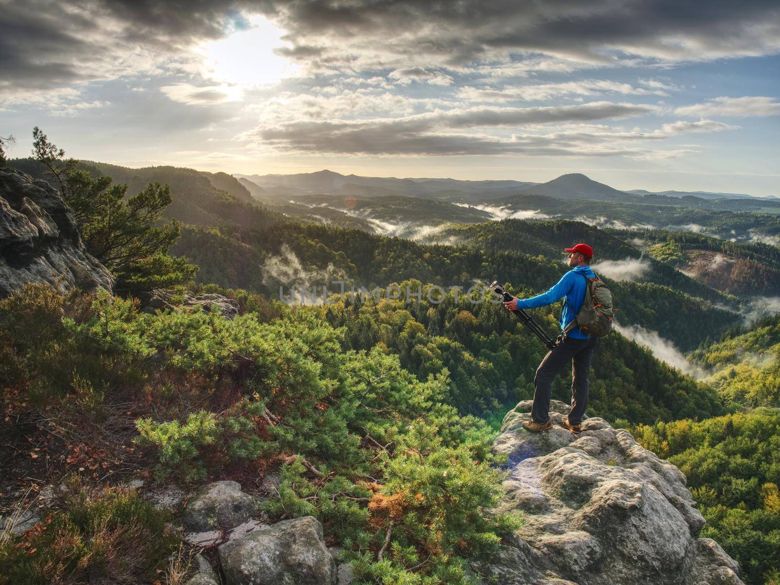 Photographer works. Amateur photographer takes photos with mirror camera on neck. Dreamy foggy landscape