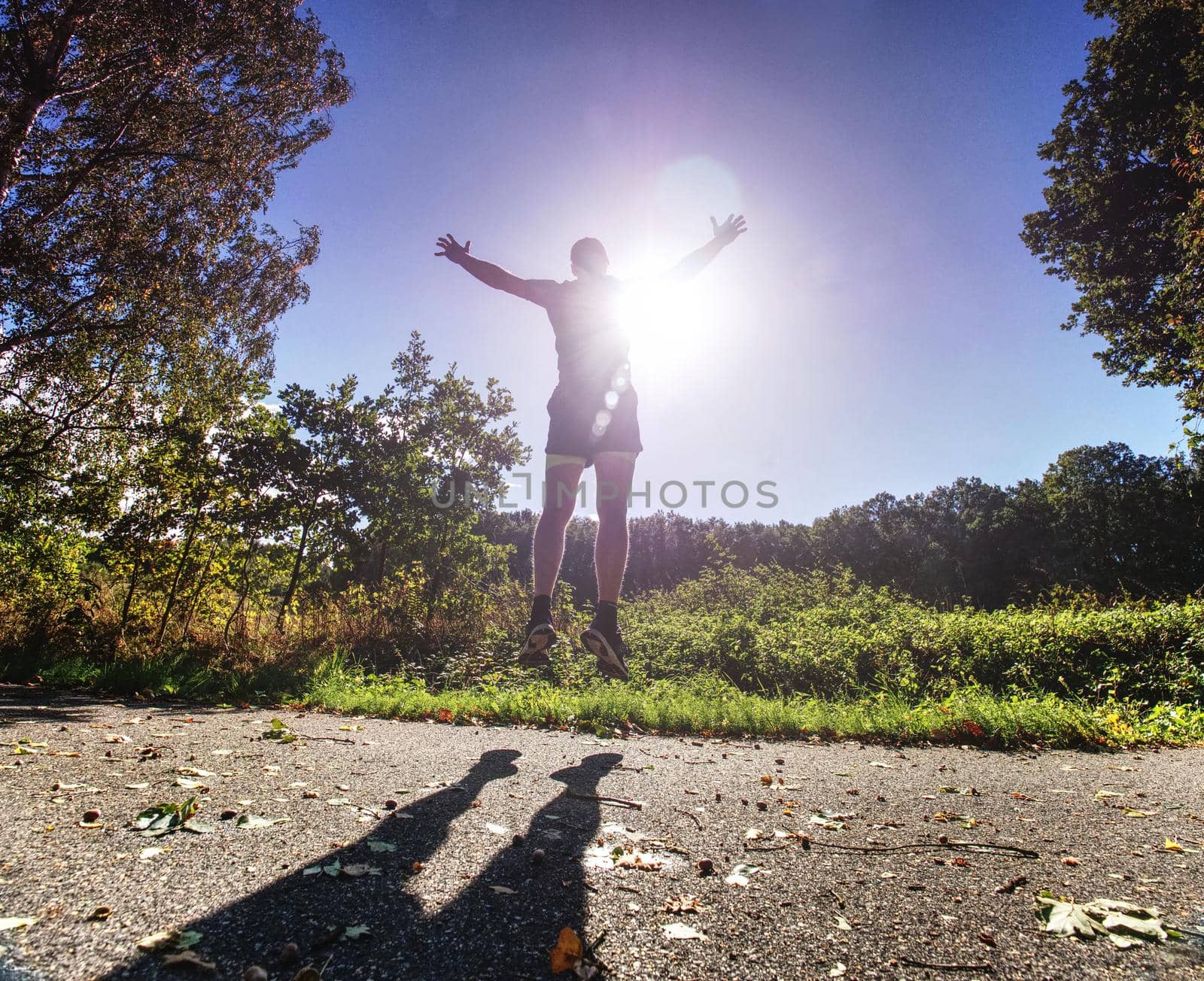 Action man, full of strength sportsman wearing shorts and sneakers, he is running a marathon, 