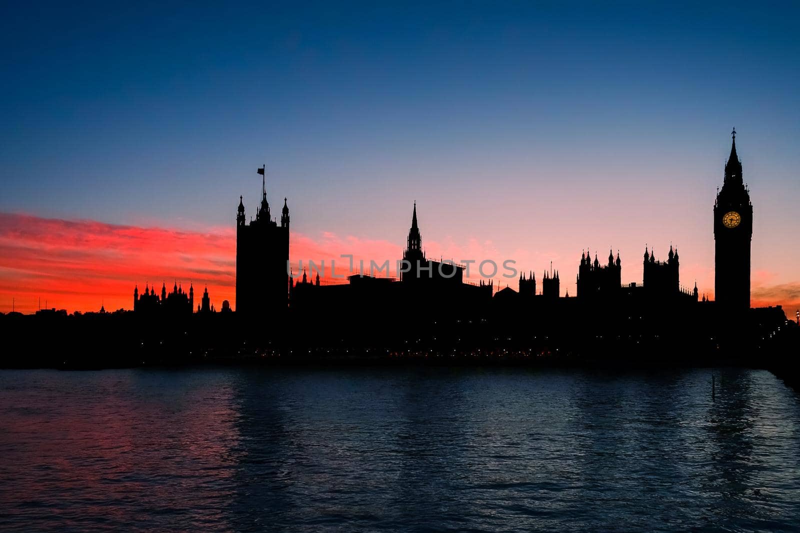 London, England - October 18 2016: Silhouette of Elizabeth Tower, Big Ben, and the Houses of Parliament against a deep orange sunset