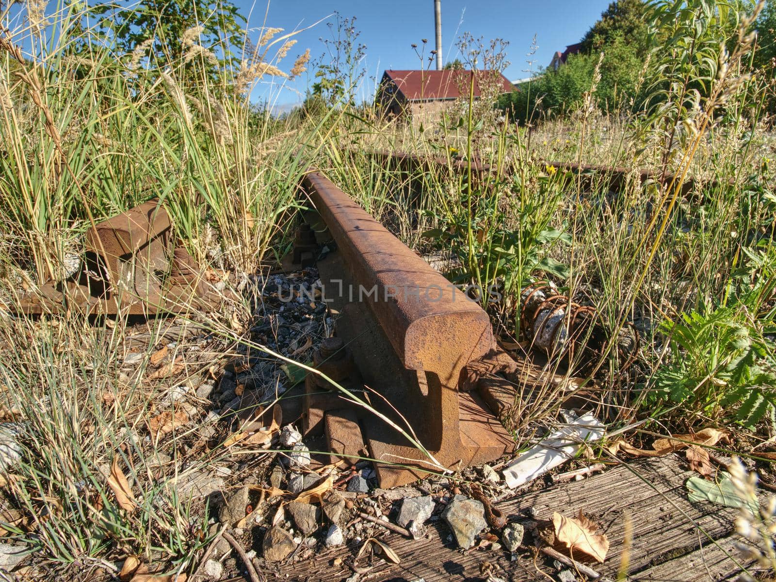 Rusty train railway detail, granite stones between rails by rdonar2