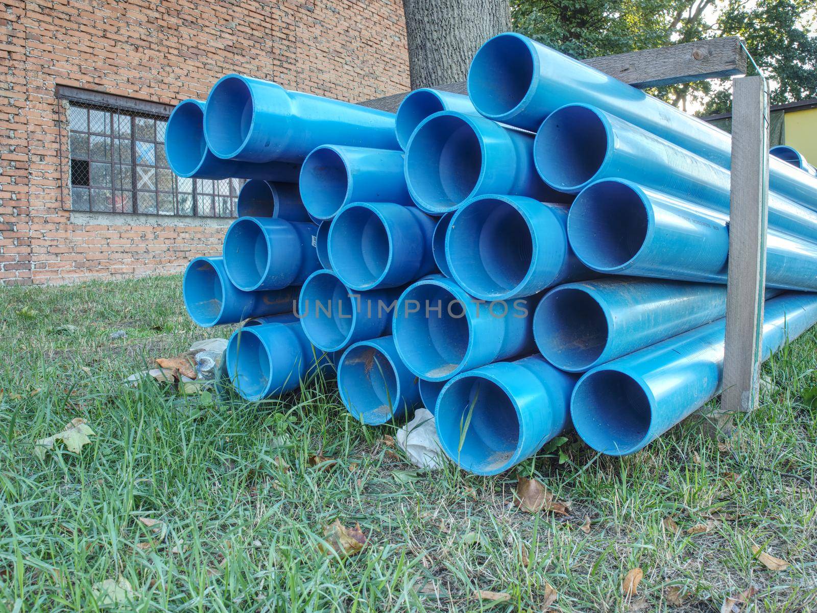 Bundles of blue plastic pipes for water transport. Pipe batch construction site.