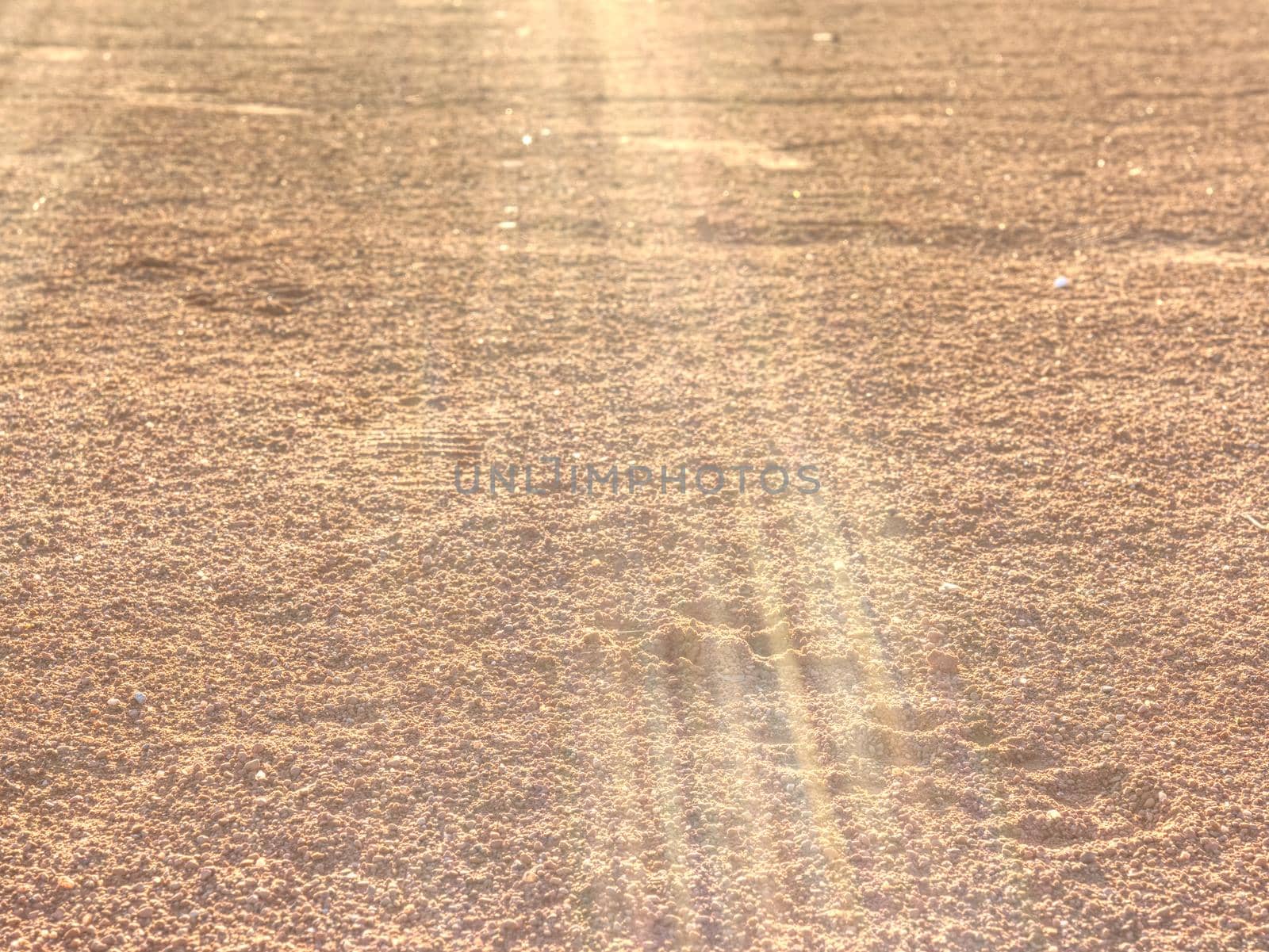 Footprints and service marks on tennis court details. Dry light red crushed bricks surface on outdoor tennis ground. Rough texture against sun