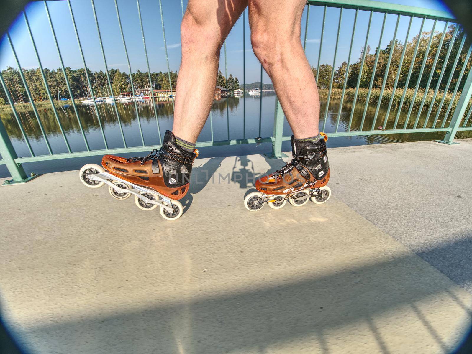 Doksy range, Czech Republic, 9th of October 2018.  Active lifestyle man enjoy sports and freedom.  Fit man roller skates riding outdoors on sea bridge
