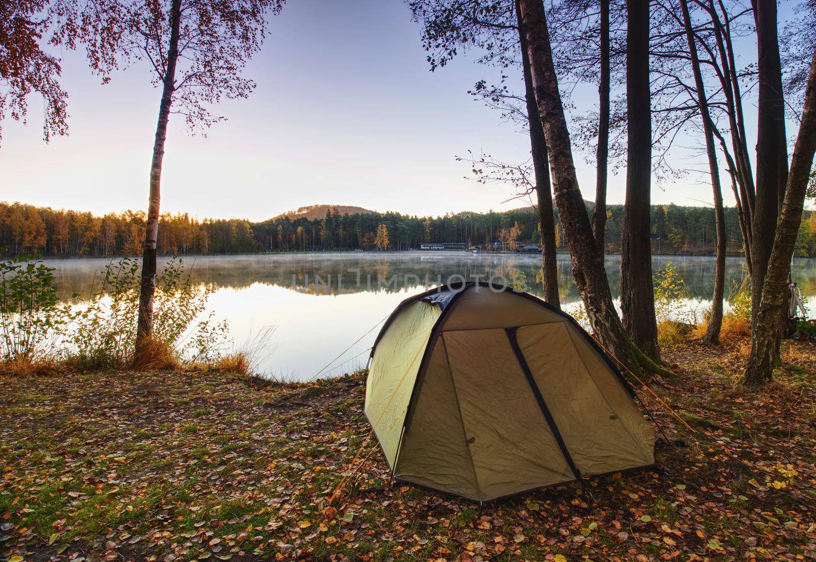 Camping at lake. Fisherman green tent at lake  by rdonar2